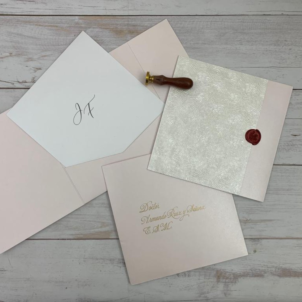 Invitación de matrimonio con relieve de rosas y lacre rojo