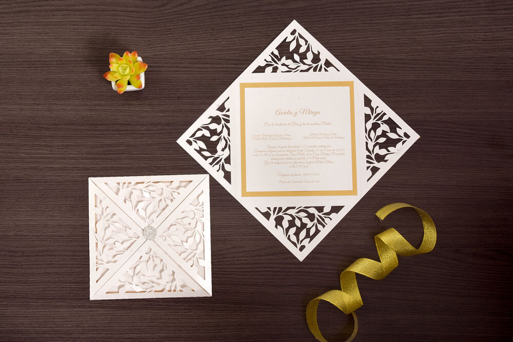 Invitación de matrimonio troquelada con hojas y marco dorado