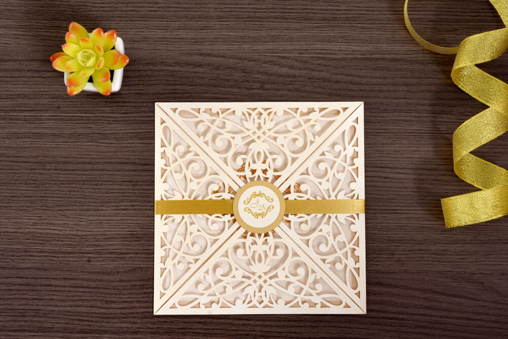 Invitación de matrimonio troquelada con arabescos y medallón dorado