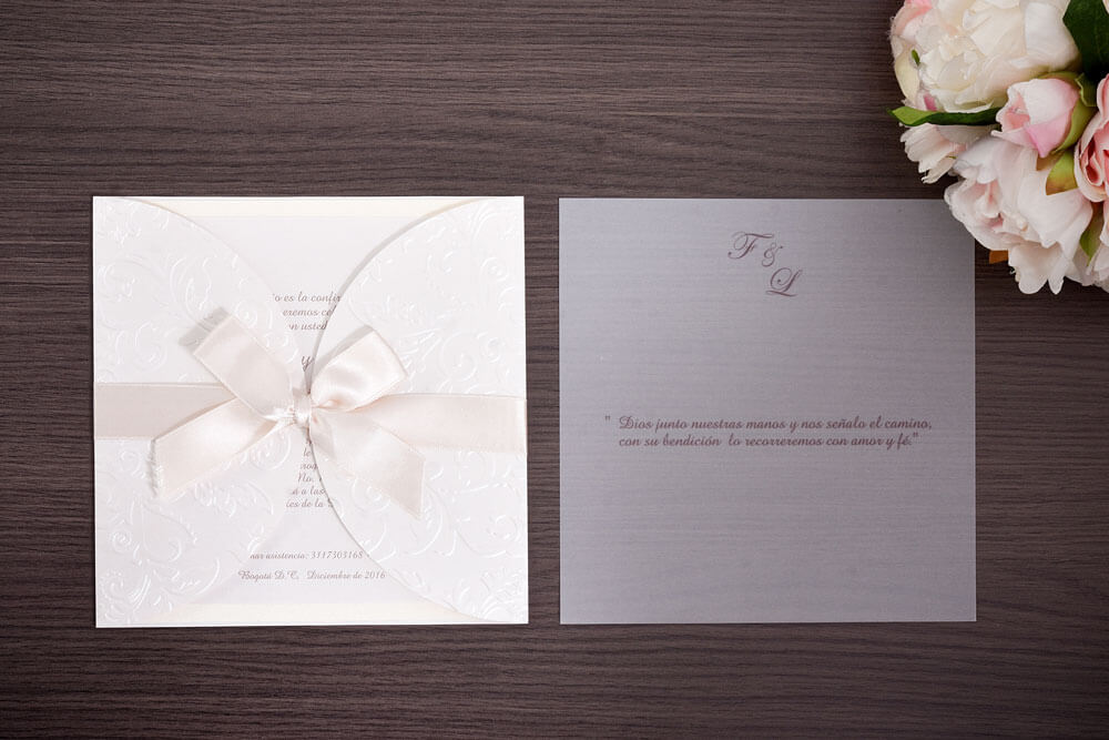 Invitación de matrimonio con relieve floral y lazo de raso marfil