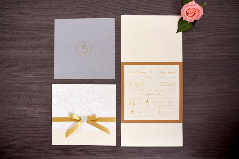 Invitación de matrimonio con lazo dorado y broche de cristales