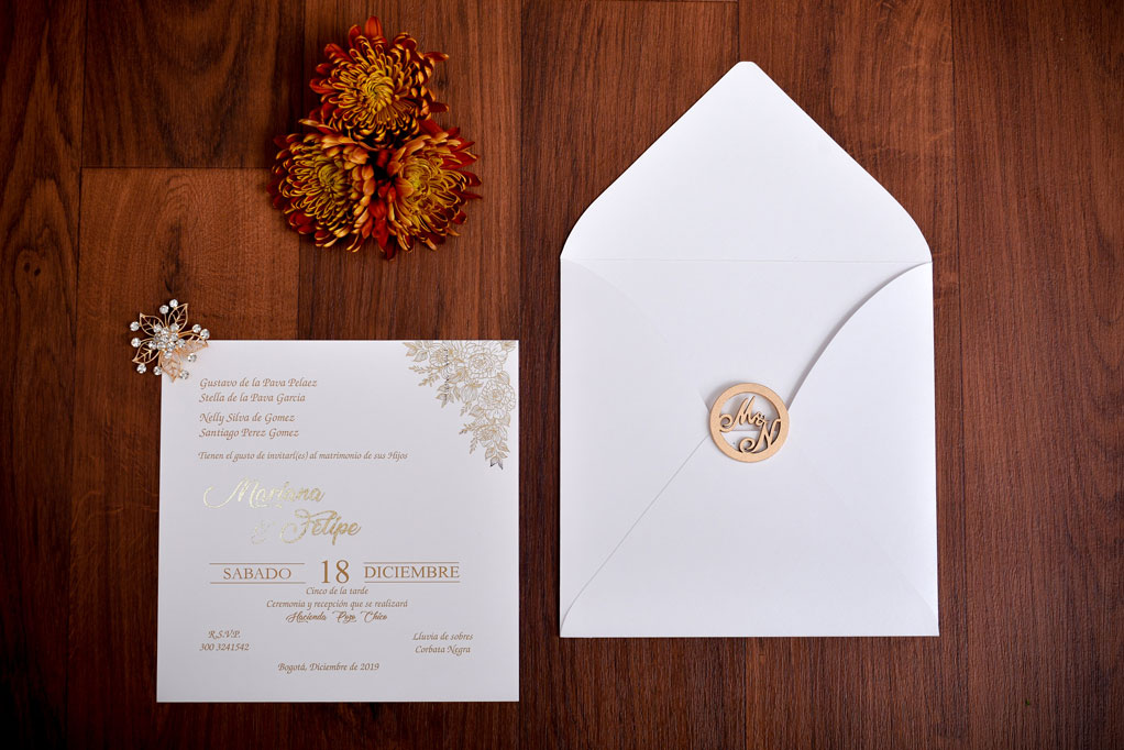 Invitación de matrimonio con rosas en foil dorado y broche