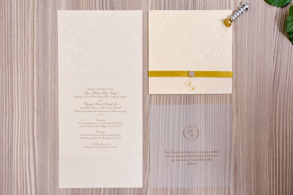 Invitación de matrimonio marfil con damasco en relieve y monograma dorado