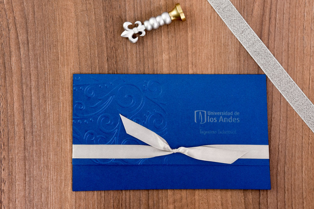 Invitación de grado azul con relieve de arabescos y lazo marfil