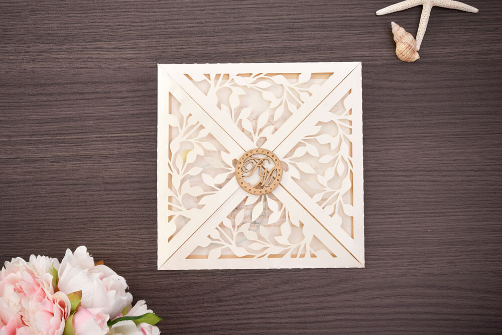 Invitación de matrimonio troquelada con follaje y sello de madera